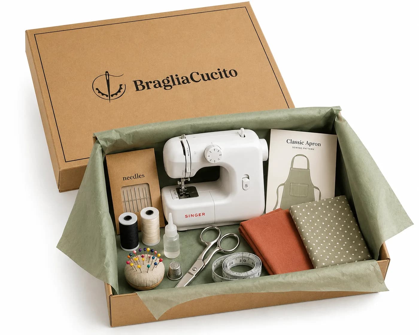 The Sewing Kit opened: sewing machine, tools, fabric and pattern in the Braglia Cucito kraft box